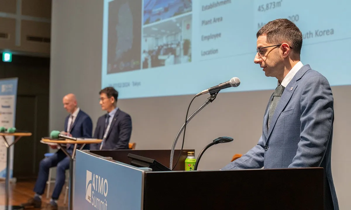 Gabriele Sernani presenting at ATMO APAC 2024 Summit, with Jan Dusek from ATMOsphere and Kim Seungjae from Baekyangsa Nonghyup in the background.